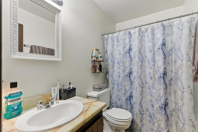 bathroom with toilet, vanity, and a shower with curtain
