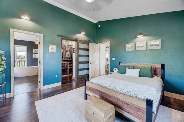 3570 Juniper Dr, Helena, MT 59602 - bedroom featuring wood finished floors, a barn door, a spacious closet, a closet, and a ceiling fan