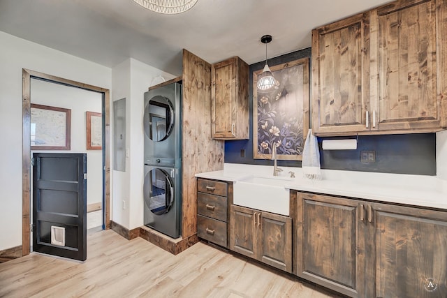 3570 Juniper Dr, Helena, MT 59602 - kitchen with stacked washer / drying machine, light wood-style flooring, light countertops, and decorative light fixtures