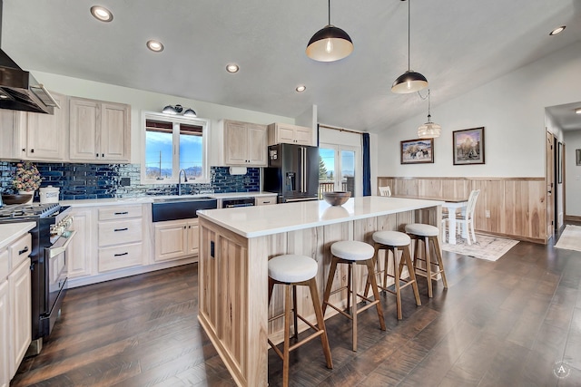 3570 Juniper Dr, Helena, MT 59602 - kitchen with stainless steel range with gas stovetop, black fridge, vaulted ceiling, a kitchen island, and dark wood-style floors