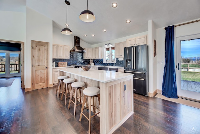 3570 Juniper Dr, Helena, MT 59602 - kitchen with high end fridge, wall chimney exhaust hood, a kitchen island, a breakfast bar area, and backsplash