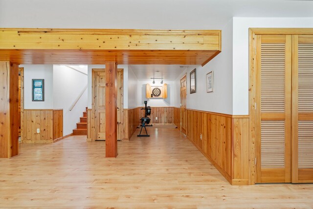 1000 Kelley Rd, Columbia Falls, MT 59912 - corridor featuring wainscoting, light wood finished floors, wooden walls, and stairway