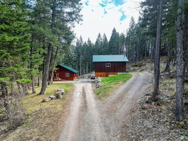 1000 Kelley Rd, Columbia Falls, MT 59912 - view of front of house featuring dirt driveway, a wooded view, and metal roof