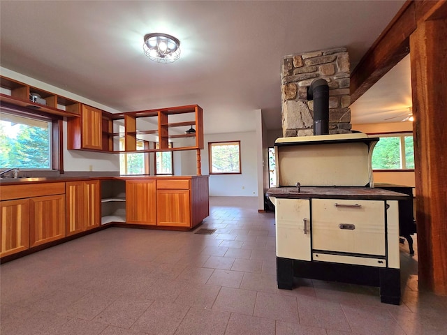 225 Marten Creek Rd, Trout Creek, MT 59874 - kitchen featuring open shelves, a wood stove, brown cabinetry, and dark countertops