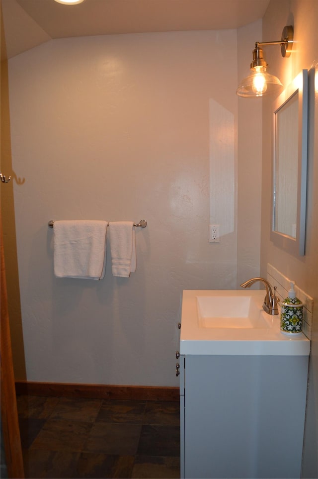 113 Cougar Trl, Whitefish, MT 59937 - bathroom featuring baseboards, vaulted ceiling, and vanity