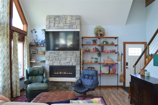 113 Cougar Trl, Whitefish, MT 59937 - living area with vaulted ceiling, a stone fireplace, a wealth of natural light, and wood finished floors