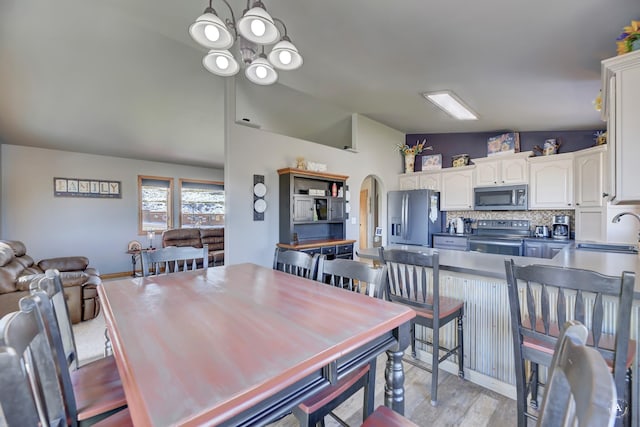 24 Hilltop Dr, Clancy, MT 59634 - dining room featuring arched walkways, light wood-style floors, and vaulted ceiling