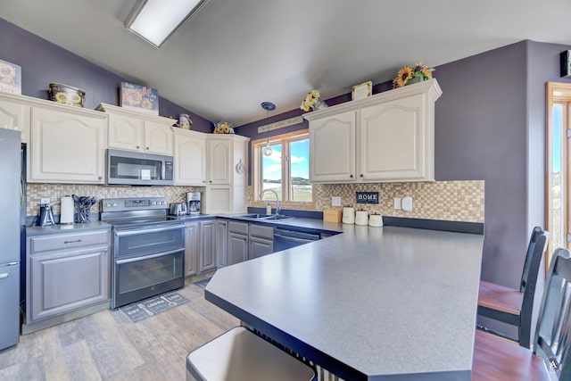 24 Hilltop Dr, Clancy, MT 59634 - kitchen featuring stainless steel appliances, lofted ceiling, light wood-style floors, backsplash, and a peninsula