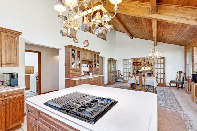2549 Horseshoe Hills Trl, Seeley Lake, MT 59868 - kitchen with a chandelier, light countertops, black gas cooktop, light tile patterned floors, and brown cabinets