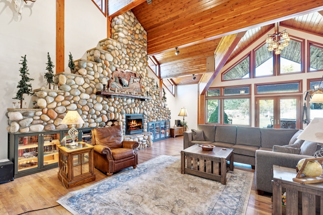 2549 Horseshoe Hills Trl, Seeley Lake, MT 59868 - living room featuring a stone fireplace, hardwood / wood-style floors, high vaulted ceiling, plenty of natural light, and a wooden ceiling with exposed beams