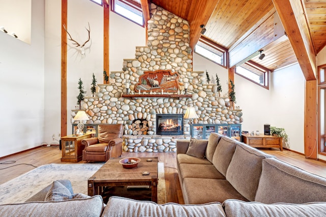 2549 Horseshoe Hills Trl, Seeley Lake, MT 59868 - living area featuring wood finished floors, high vaulted ceiling, a wood ceiling with exposed beams, a glass covered fireplace, and healthy amount of natural light