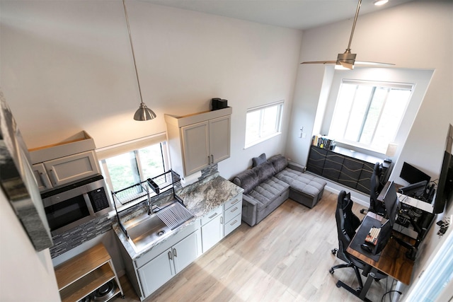 kitchen featuring a high ceiling, a healthy amount of sunlight, and a sink