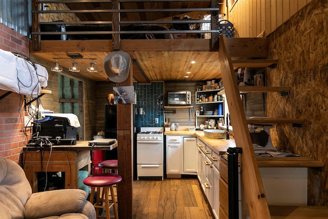 kitchen with open shelves, white gas range, butcher block counters, light wood finished floors, and white cabinets