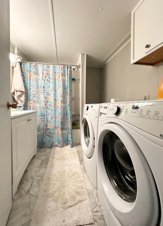 clothes washing area with marble finish floor, a textured ceiling, and washing machine and clothes dryer
