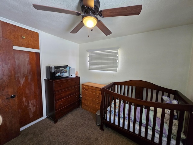 carpeted bedroom featuring a ceiling fan and a crib