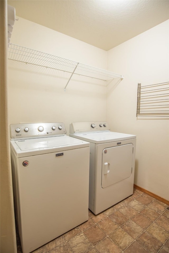 2226 Burlington Ave Unit A, Missoula, MT 59801 - washroom featuring stone finish floor, baseboards, laundry area, and independent washer and dryer