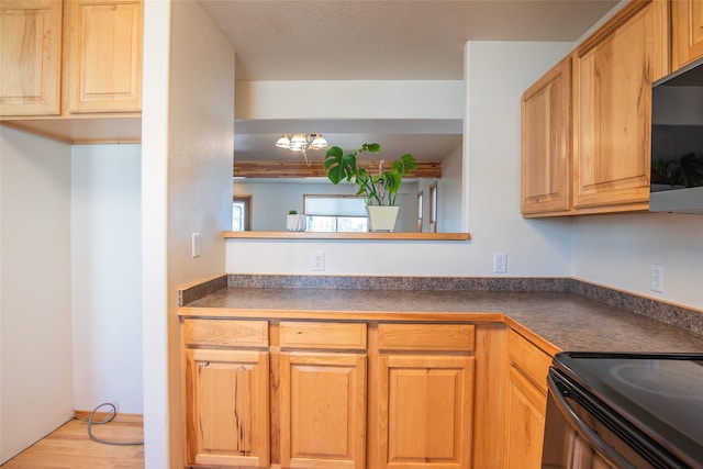 2226 Burlington Ave Unit A, Missoula, MT 59801 - kitchen with dark countertops, a notable chandelier, light wood-type flooring, and electric range