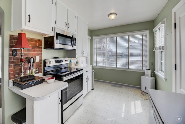 730 N Montana Ave, Helena, MT 59601 - kitchen featuring light floors, stainless steel appliances, light countertops, white cabinets, and baseboards