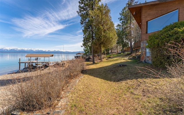 view of yard featuring a boat dock and a water and mountain view