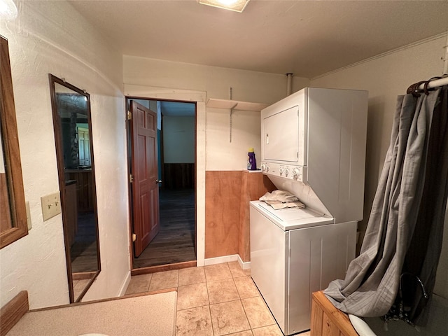 clothes washing area featuring stacked washer / dryer and light tile patterned floors