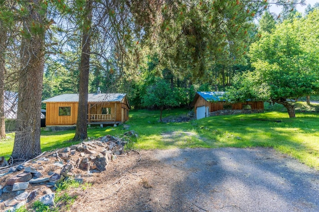 view of yard with a garage and an outbuilding