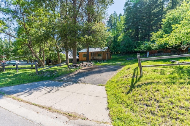 view of front of property with fence, aphalt driveway, and a front yard