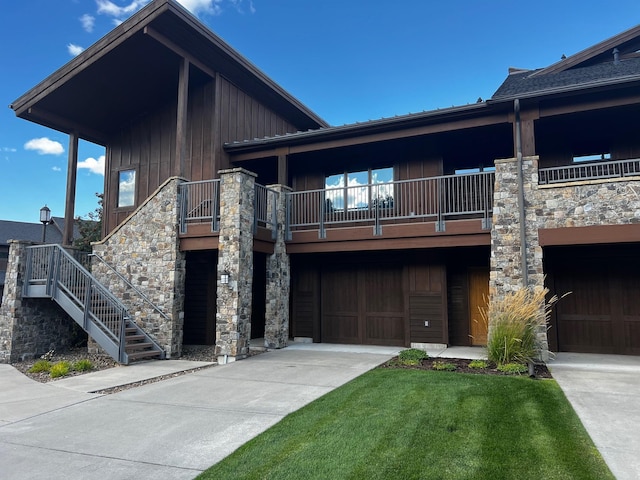 105 Oliver Ln Unit 7, Bigfork, MT 59911 - view of front facade featuring board and batten siding, stone siding, concrete driveway, stairs, and an attached garage