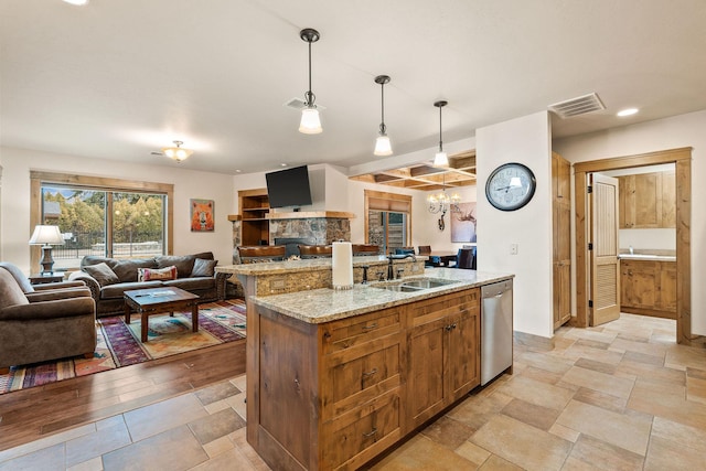 105 Oliver Ln Unit 7, Bigfork, MT 59911 - kitchen featuring dishwasher, open floor plan, brown cabinetry, pendant lighting, and an island with sink