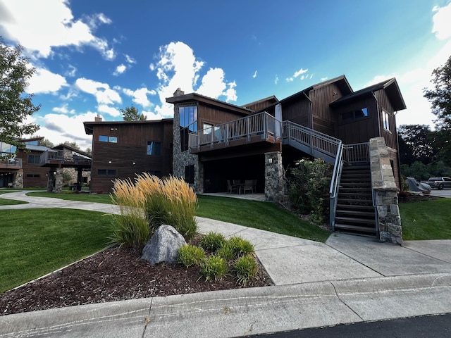 105 Oliver Ln Unit 7, Bigfork, MT 59911 - view of front of property featuring a front lawn, stairway, stone siding, and a wooden deck