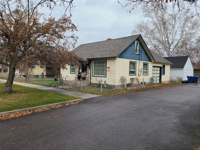 view of side of property featuring a shingled roof and fence