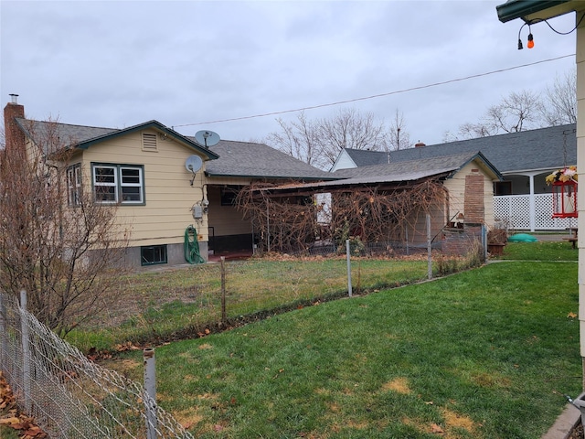 bungalow-style house with a chimney, roof with shingles, and a fenced front yard