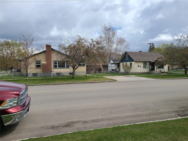 view of home's exterior featuring fence, a chimney, and a yard