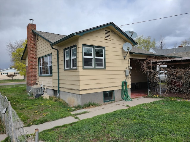rear view of house featuring a lawn and a chimney