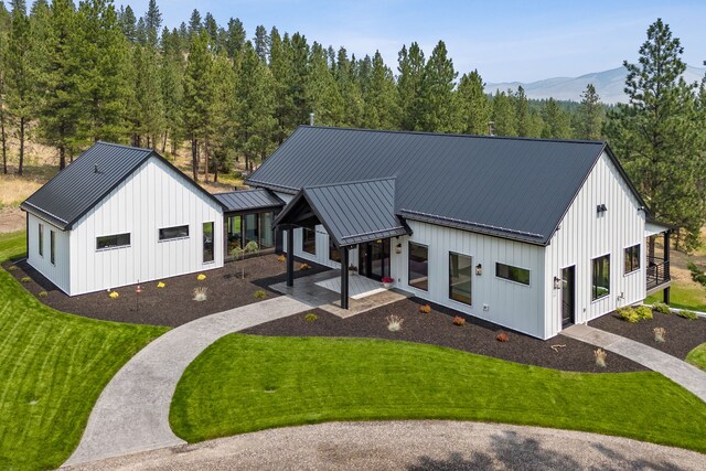 5608 Trinity Way, Florence, MT 59833 - view of front of property with a mountain view, a standing seam roof, board and batten siding, and a front yard