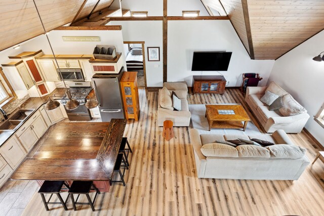 5608 Trinity Way, Florence, MT 59833 - living area featuring light wood-type flooring, vaulted ceiling with beams, and wooden ceiling