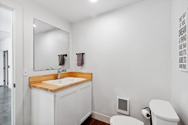 5608 Trinity Way, Florence, MT 59833 - bathroom featuring baseboards, heating unit, vanity, and toilet