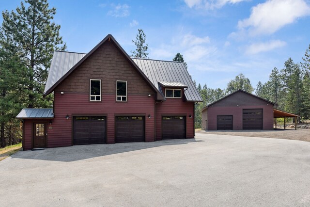 5608 Trinity Way, Florence, MT 59833 - view of side of property featuring a garage, a standing seam roof, an outdoor structure, and metal roof