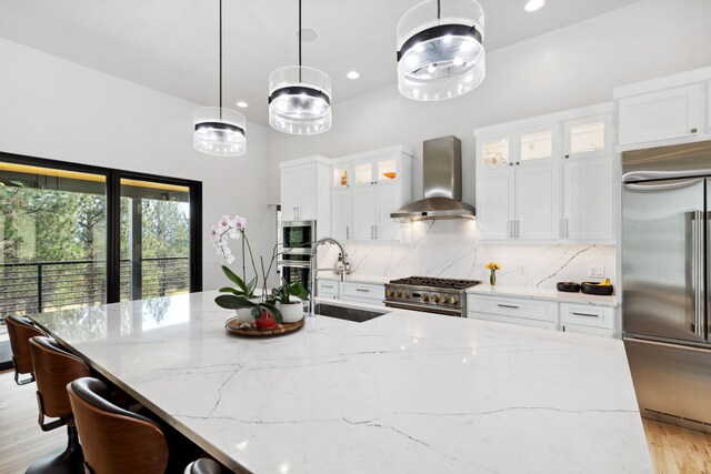 5608 Trinity Way, Florence, MT 59833 - kitchen with a sink, a center island with sink, decorative backsplash, built in appliances, and wall chimney range hood