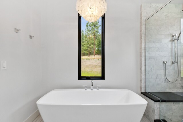 5608 Trinity Way, Florence, MT 59833 - bathroom featuring a notable chandelier, a freestanding bath, and a stall shower