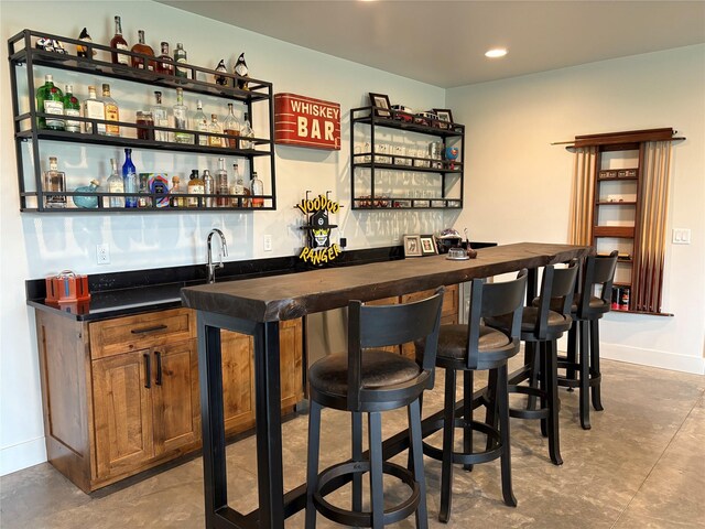 5608 Trinity Way, Florence, MT 59833 - bar with baseboards, recessed lighting, finished concrete flooring, and wet bar