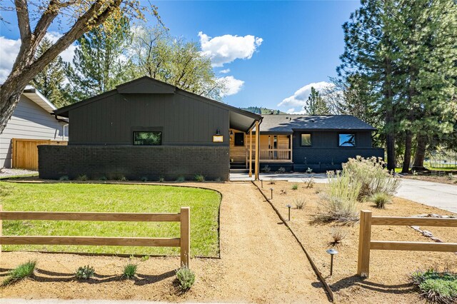 4210 Lincoln Rd, Missoula, MT 59802 - view of front of home with covered porch, fence, brick siding, and concrete driveway