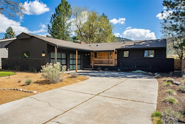 4210 Lincoln Rd, Missoula, MT 59802 - single story home with driveway, brick siding, covered porch, an attached garage, and roof with shingles