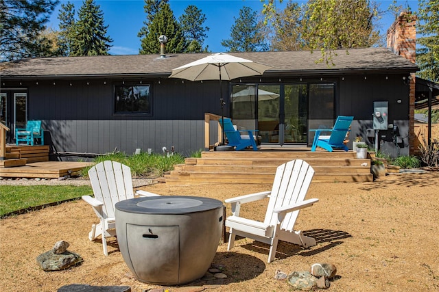 4210 Lincoln Rd, Missoula, MT 59802 - rear view of property with a fire pit, a shingled roof, a chimney, and a wooden deck