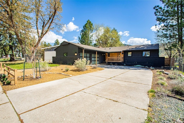 4210 Lincoln Rd, Missoula, MT 59802 - ranch-style home featuring covered porch, concrete driveway, an attached garage, and fence