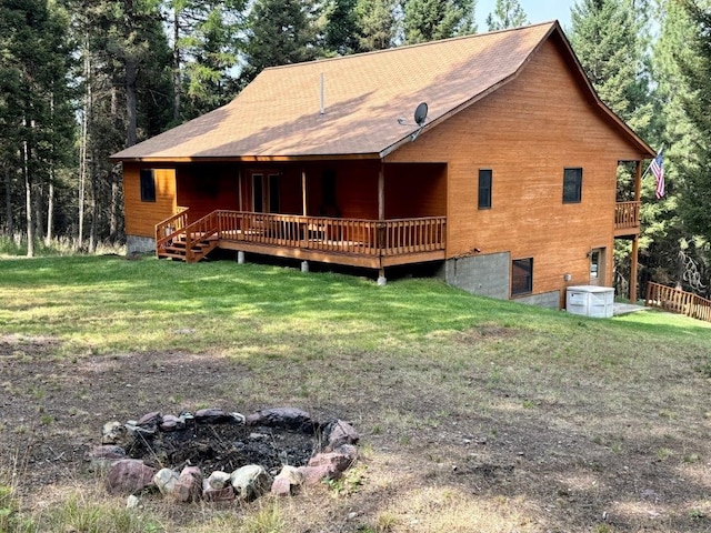 1180 Grandview Dr, Seeley Lake, MT 59868 - back of house with a lawn, a deck, and a fire pit