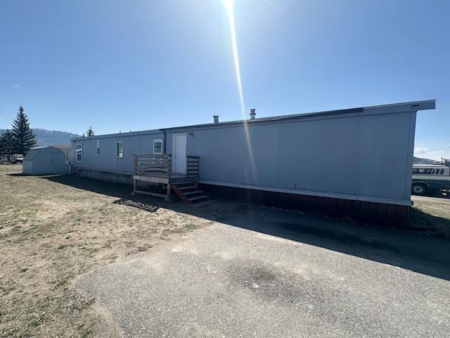 back of property with an outbuilding and a storage shed