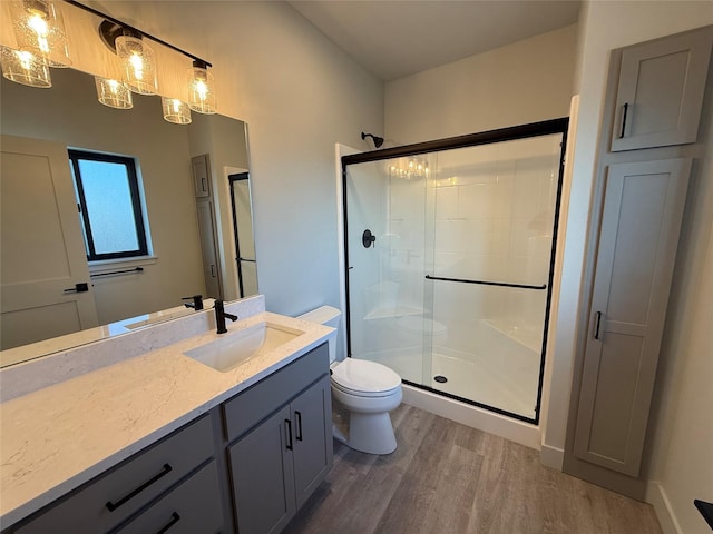 3431 Goldenrod Ln, Kalispell, MT 59901 - bathroom featuring vanity, a shower stall, toilet, and wood finished floors