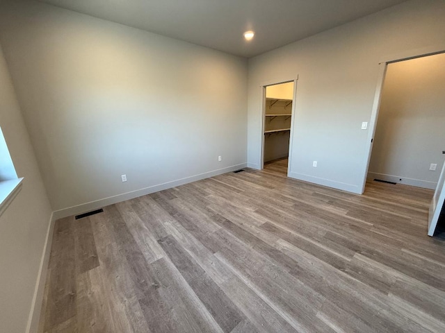 3431 Goldenrod Ln, Kalispell, MT 59901 - unfurnished bedroom featuring visible vents, wood finished floors, baseboards, recessed lighting, and a spacious closet