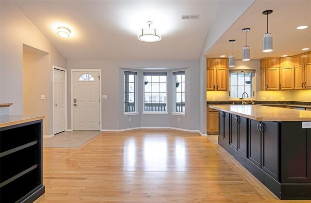 4891 Christian Dr, Missoula, MT 59803 - kitchen with vaulted ceiling, a center island, stainless steel fridge with ice dispenser, decorative light fixtures, and visible vents