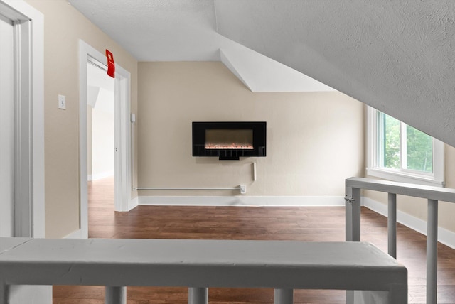 360 White House Ln, Bonner, MT 59823 - interior space featuring a textured ceiling, wood finished floors, baseboards, vaulted ceiling, and a warm lit fireplace